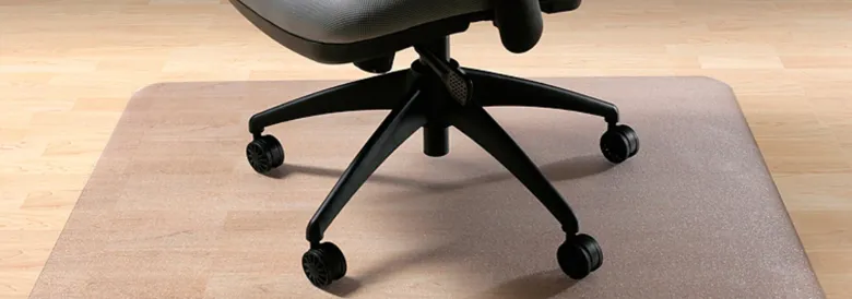 Transparente Bodenschutzmatte unter einem Bürostuhl auf einem Holzboden